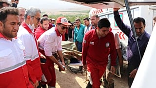 Des secouristes du Croissant rouge iranien à Estahban, Iran, après les inondations, le 23 juillet 2023