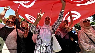 Manifestantes tunecinos izan una bandera el 23 de julio de 2022, durante una manifestación a lo largo de la avenida Habib Bourguiba en la capital, Túnez