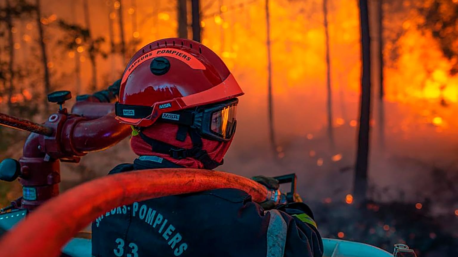 A firefighter at work at a forest fire at La Teste-de-Buch, southwestern France, late Monday, July 18, 2022. 