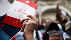 متظاهر يحمل نسخة من الدستور التونسي خلال احتجاج على الرئيس التونسي قيس سعيد في تونس العاصمة، السبت 18 سبتمبر 2021. 