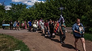 Ucranianos dirigiéndose al funeral de Anna Protsenko, asesinada por un misil ruso, tras volver a Pokrovsk, su ciudad natal.