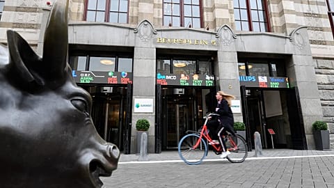 A woman cycles past the Euronext Amsterdam stock exchange in Amsterdam on April 7, 2021. 