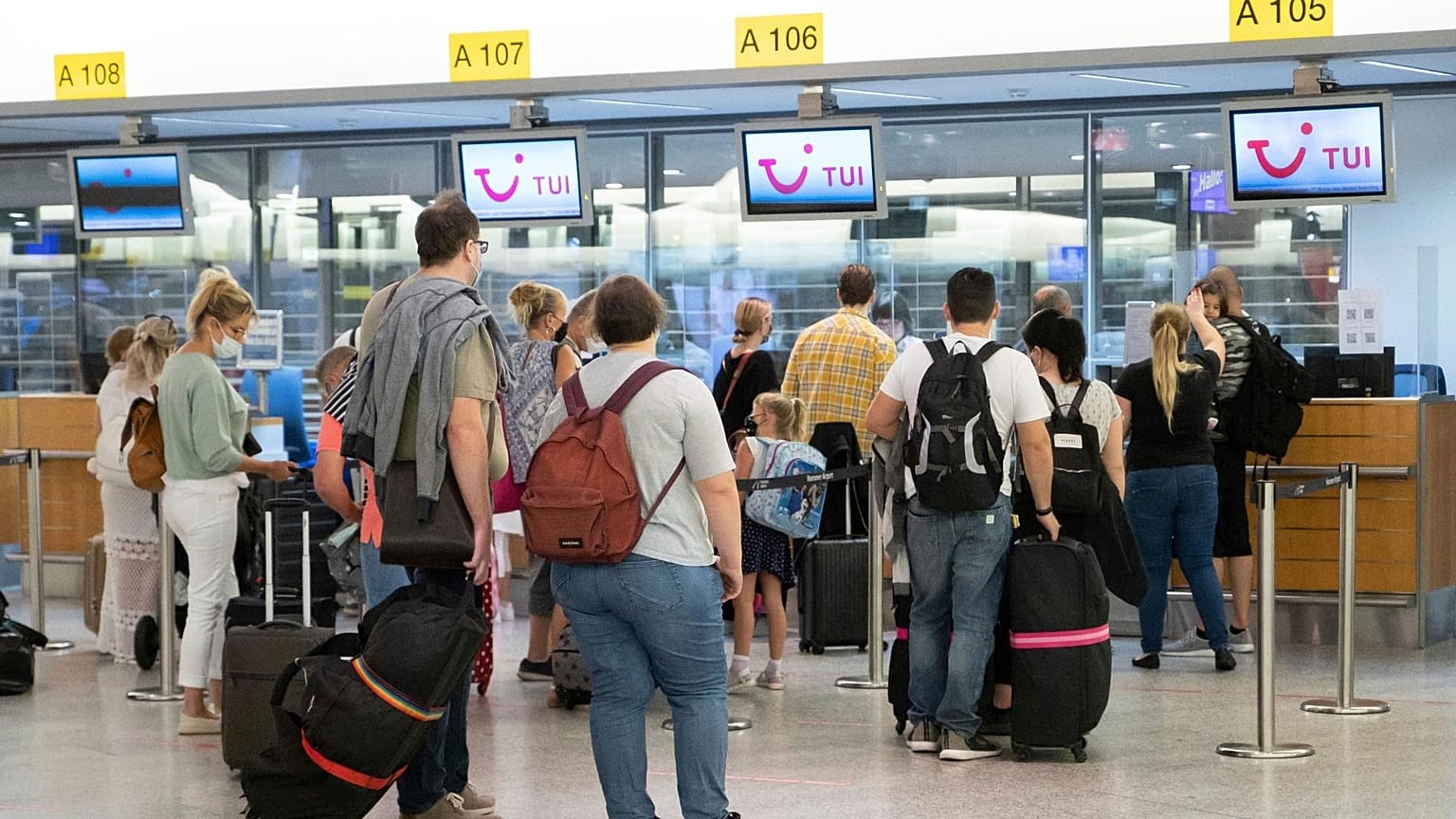 Passengers hand in their luggage at TUI check-in counters at the airport in Hanover, Germany.