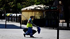 Uma mulher, varredora de rua, caminha na rua L'Hospitalet del Llobregat, perto de Barcelona, a 19 de julho de 2022. Espanha