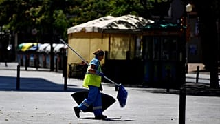 Uma mulher, varredora de rua, caminha na rua L'Hospitalet del Llobregat, perto de Barcelona, a 19 de julho de 2022. Espanha