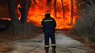 Un pompier face à un feu de forêt près de Vatera, sur l'île de Lesbos, Grèce, le 23 juillet 2022