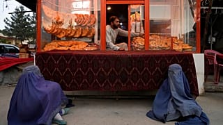 Deux mendiantes attendent de recevoir l'aumône devant une boulangerie à Kaboul, en Afghanistan, dimanche 15 mai 2022.