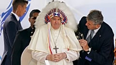 El Papa Francisco se pone un tocado que le fue regalado durante una visita con los pueblos indígenas en Maskwaci, la antigua Escuela Residencial Ermineskin