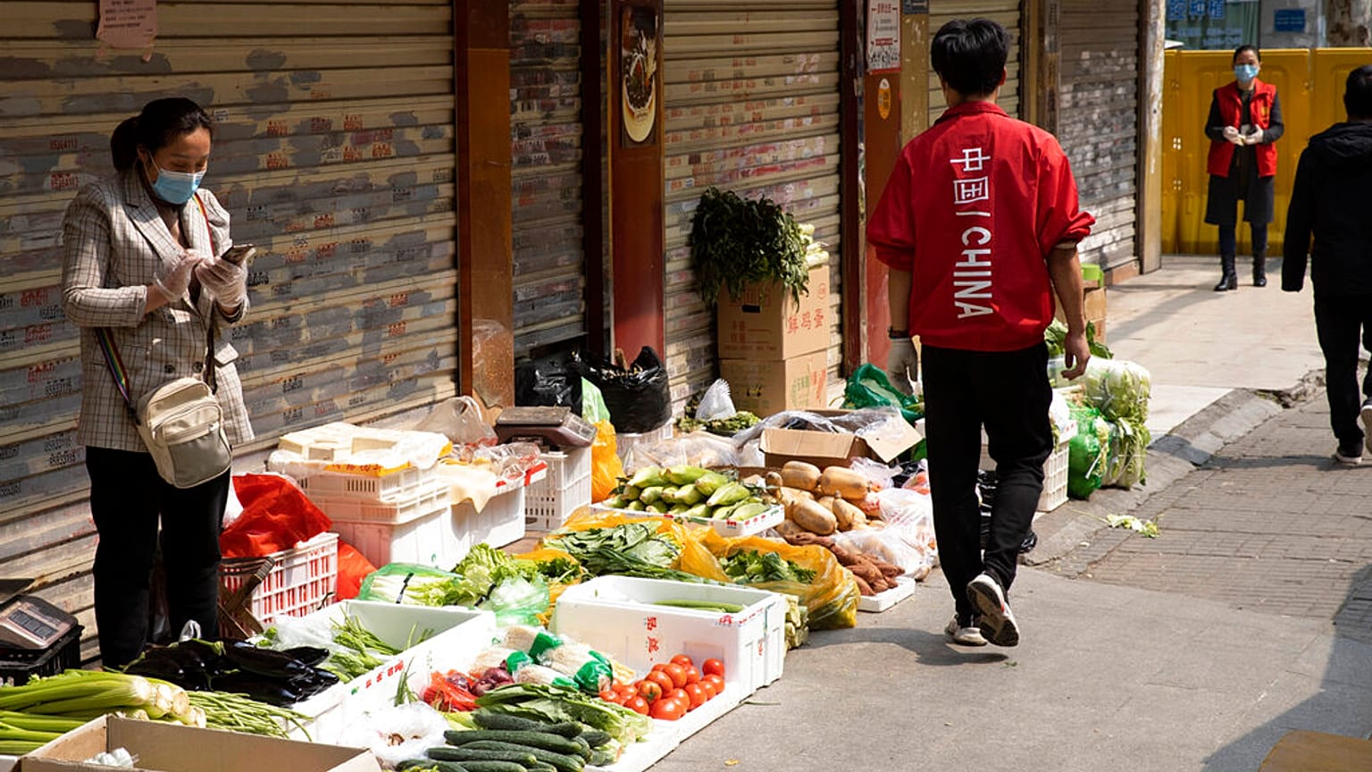 Une vendeuse attend patiente devant son étal. Son marché a Wuhan a été partiellement fermé à cause de la pandémie. Avril 2020