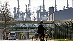 A worker rides his bicycle to the BP oil refinery Ruhr Oil in Gelsenkirchen, Germany, Monday, March 28, 2022.