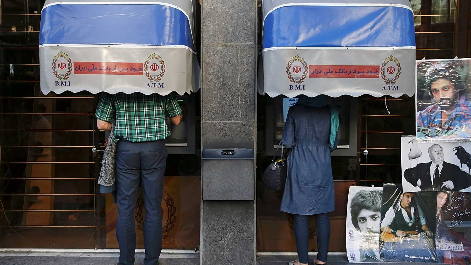 يستخدم الإيرانيون ماكينات الصرف الآلي لبنك ملي إيران في وسط مدينة طهران، إيران، 4 أبريل 2015 