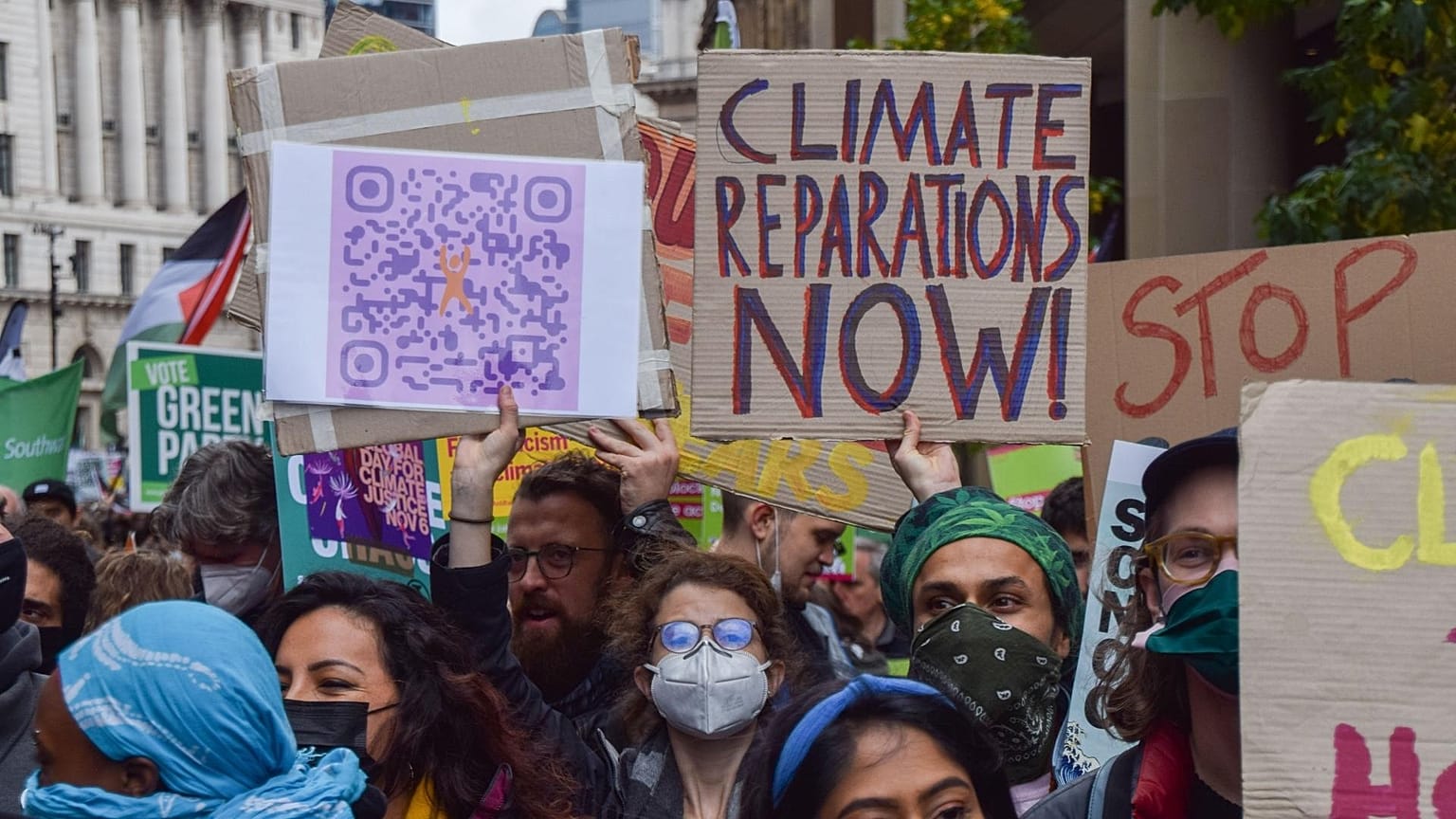 A protester holds a 'Climate Reparations Now' placard during the demonstration in the City of London.