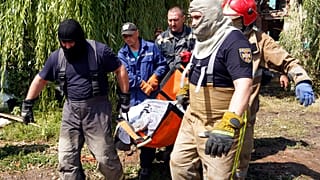 Rescuers move a covered body of a woman killed by Russian missile attack on Monday in Chuhuiv, Kharkiv region, Ukraine, Tuesday, July 26, 2022.