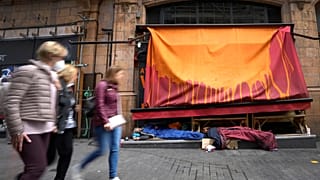 Pedestrians pass homeless people sleeping in front of a closed retail unit in London, 13 April 2022 (AP Photo/Kirsty Wigglesworth)