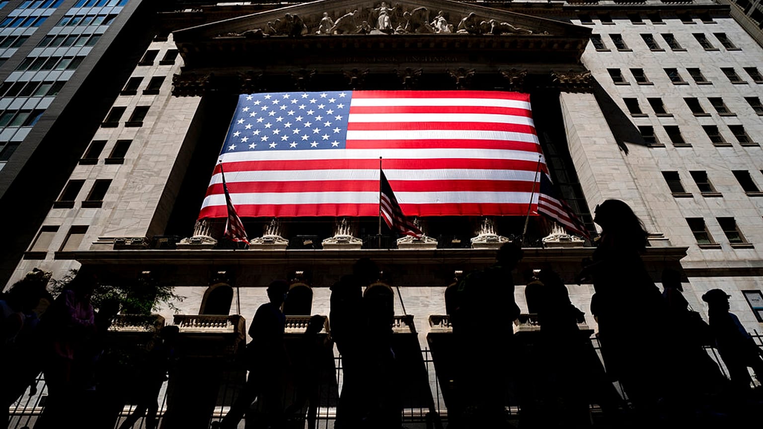 People walk past the New York Stock Exchange on Wednesday, June 29, 2022 in New York.