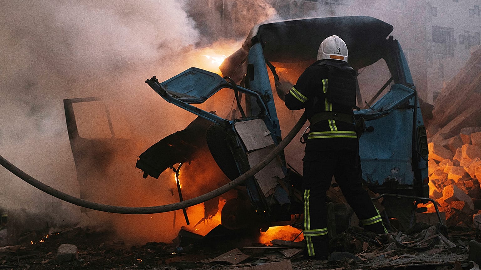 Firefighters work at the site of fire after Russian shelling in Mykolaiv on 18 June 2022