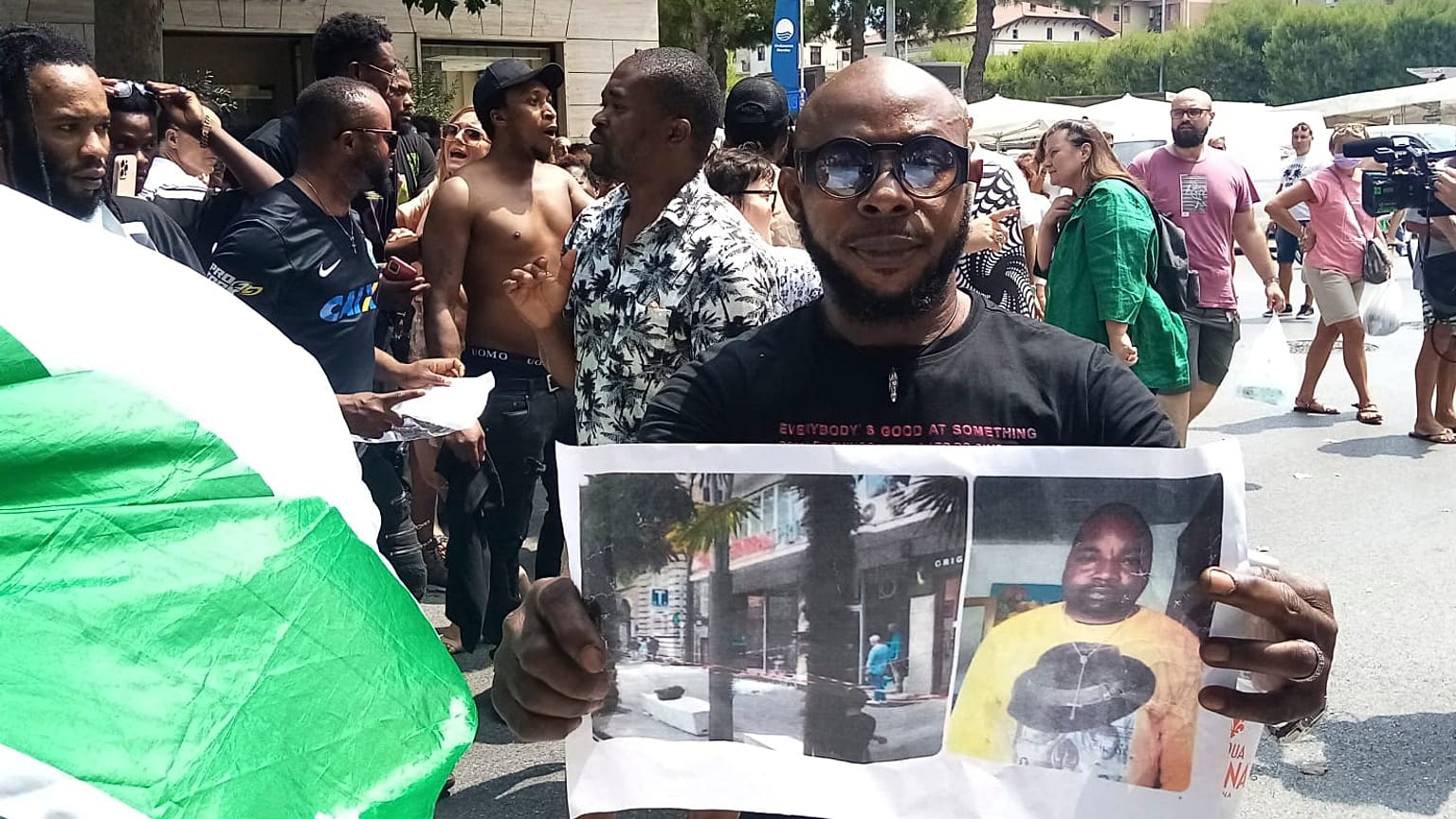 Un hombre muestra una foto de la víctima, el vendedor ambulante nigeriano Alika Ogorchukwu, en Civitanova Marche, Italia, el 30 de julio de 2022