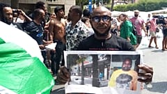 Un hombre muestra una foto de la víctima, el vendedor ambulante nigeriano Alika Ogorchukwu, en Civitanova Marche, Italia, el 30 de julio de 2022
