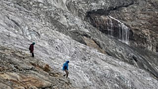 Hikers are seen walking next to the melting Fee Glacier above the Swiss alpine resort of Saas-Fee.