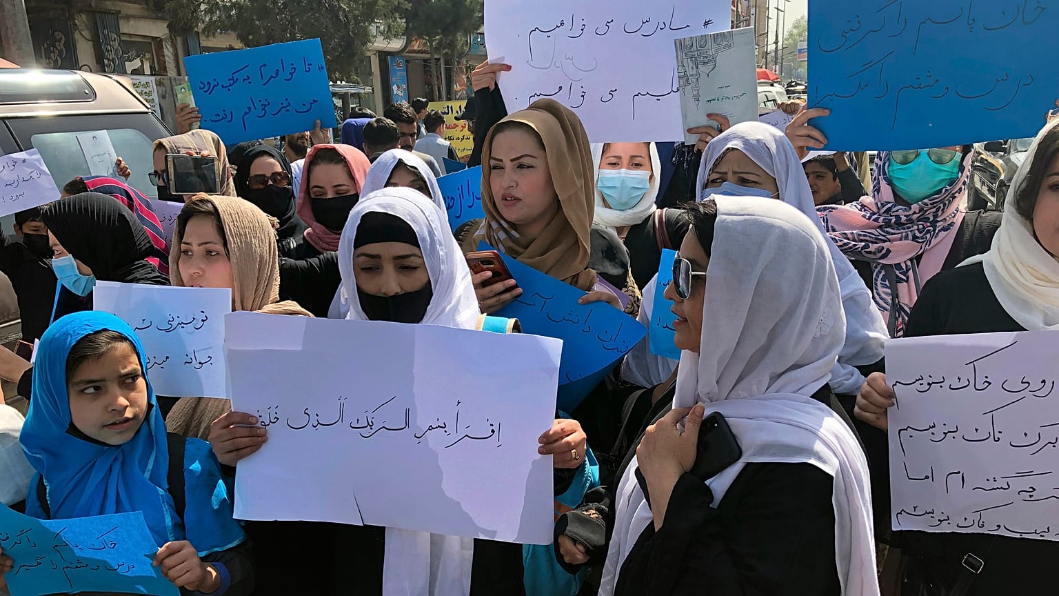 Mujeres afganas corean y sostienen carteles de protesta durante una manifestación en Kabul, Afganistán, el 26 de marzo de 2022.