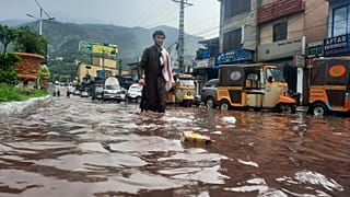 Um homem atravessa uma rua inundada em Muzaffarabad, Paquistão