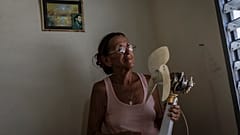 Miriam Cortés posa con su ventilador en Regla, Cuba, el lunes 1 de agosto de 2022. 