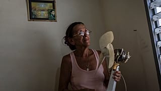 Miriam Cortés posa con su ventilador en Regla, Cuba, el lunes 1 de agosto de 2022.