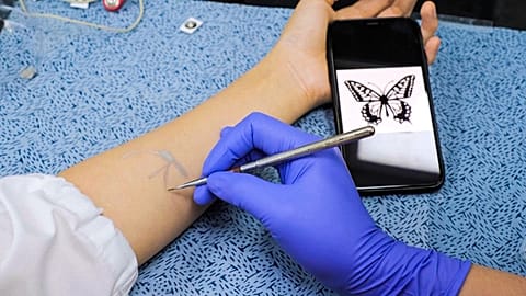 Image shows a researcher from the Korea Advanced Institute of Science and Technology applying a tattoo using 'electonic ink'.