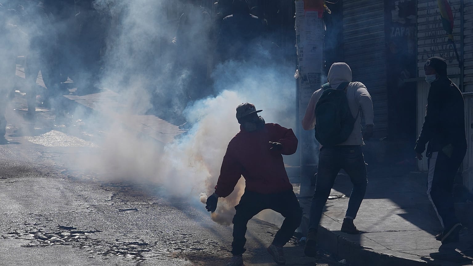 Un vendedor de coca devuelve un bote de gas lacrimógeno disparado por la policía antidisturbios durante el segundo día de protestas en La Paz
