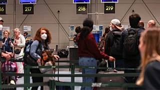 People wait on the Ryanair check-in line at Lisbon Humberto Delgado Airport