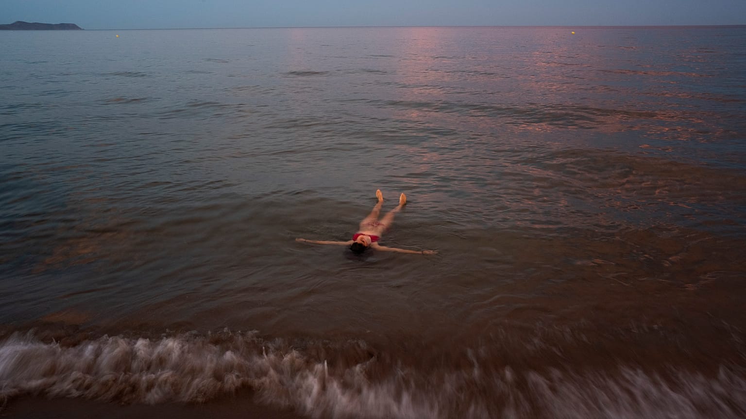 Una mujer se refresca en la playa de Sant Pere Pescador, Girona, España, el lunes 1 de agosto de 2022.