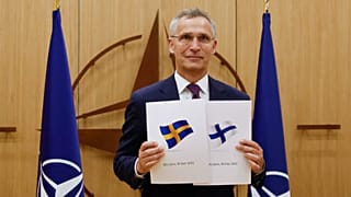 NATO Secretary-General Jens Stoltenberg displays documents as Sweden and Finland applied for membership in Brussels, Belgium, May 18, 2022.