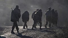 Ethnic Armenian soldiers walk along the road near the border between Nagorno-Karabakh and Armenia, Nov. 8, 2020.