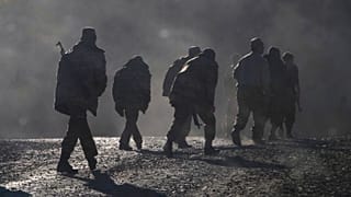 Ethnic Armenian soldiers walk along the road near the border between Nagorno-Karabakh and Armenia, Nov. 8, 2020.