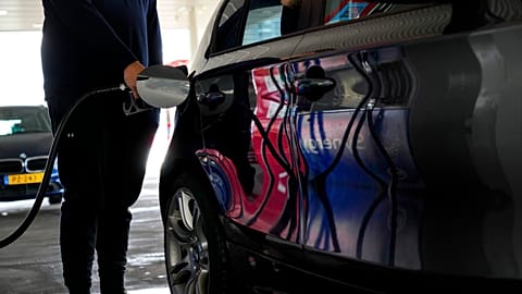 FILE - A man fills his car with gasoline at a petrol station in Amsterdam, Netherlands, on April 1, 2022. 