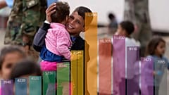 A recently evacuated young Afghan boy carries a child at the Ramstein US Air Base, Germany, Tuesday, Aug. 24, 2021