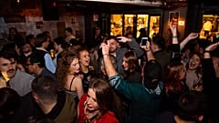 Young people are seen dancing and drinking inside a bar in Barcelona in January 2022