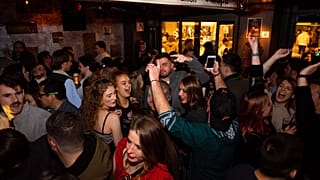 Young people are seen dancing and drinking inside a bar in Barcelona in January 2022