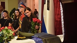 Elena Karabet, die Tochter von Olga Kachura steht am Sarg ihrer Mutter bei einer Trauerfeiern in Donezk am 4. August 2022.