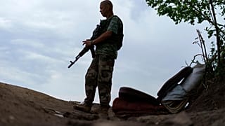 Ukrainian soldier Igor Ryazantsev with the Dnipro-1 regiment keeps watch outside his tent near Sloviansk, eastern Ukraine, 5 August 2022