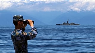 Un miembro del Ejército Popular de Liberación mira a través de unos prismáticos la fragata taiwanesa Lan Yang, el viernes 5 de agosto de 2022
