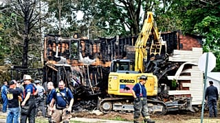 Feuerwehrleute stehen vor deer ausgebrannten Hausruine in Nescopeck (Pennsylvania)