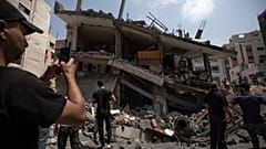 Palestinians inspect the damaged residential building after it was hit by Israeli airstrikes, in Gaza, Saturday, Aug. 6, 2022.