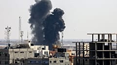 Smoke billows from a building struck during an Israeli air strike.