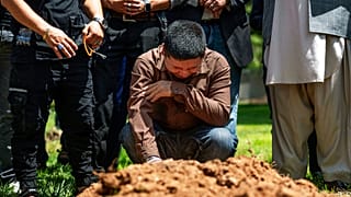 ألطاف حسين يبكي على قبر شقيقه أفتاب حسين في حديقة فيرفيو التذكارية في البوكيركي، نيو مكسيكو، يوم الجمعة 5 أغسطس 2022.