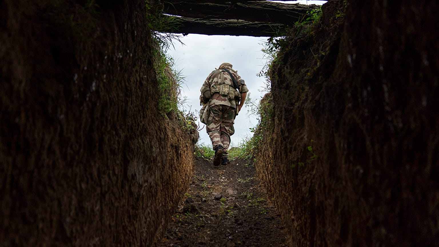 Sergeant Major Artur Shevtsov with the Dnipro-1 regiment exits a bunker at the unit's position near Sloviansk 5 August, 2022