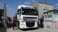 Agentes de la policía de Hamás comprueban un camión cisterna que transporta combustible mientras se le autoriza a entrar en el lado palestino