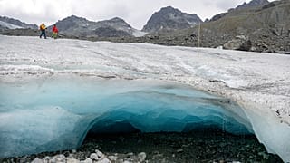 Les glaciologues Andrea Fischer et Violeta Lauria de l'Académie autrichienne des sciences marchent sur le glacier Jamtal dans le Tyrol, en Autriche (juillet 2022).