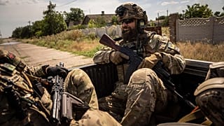 Ukrainian servicemen of "Fireflies" reconnaissance team ride to the position in the trunk of pickup at the frontline in Mykolaiv region, Ukraine, on Monday, Aug. 8, 2022. 