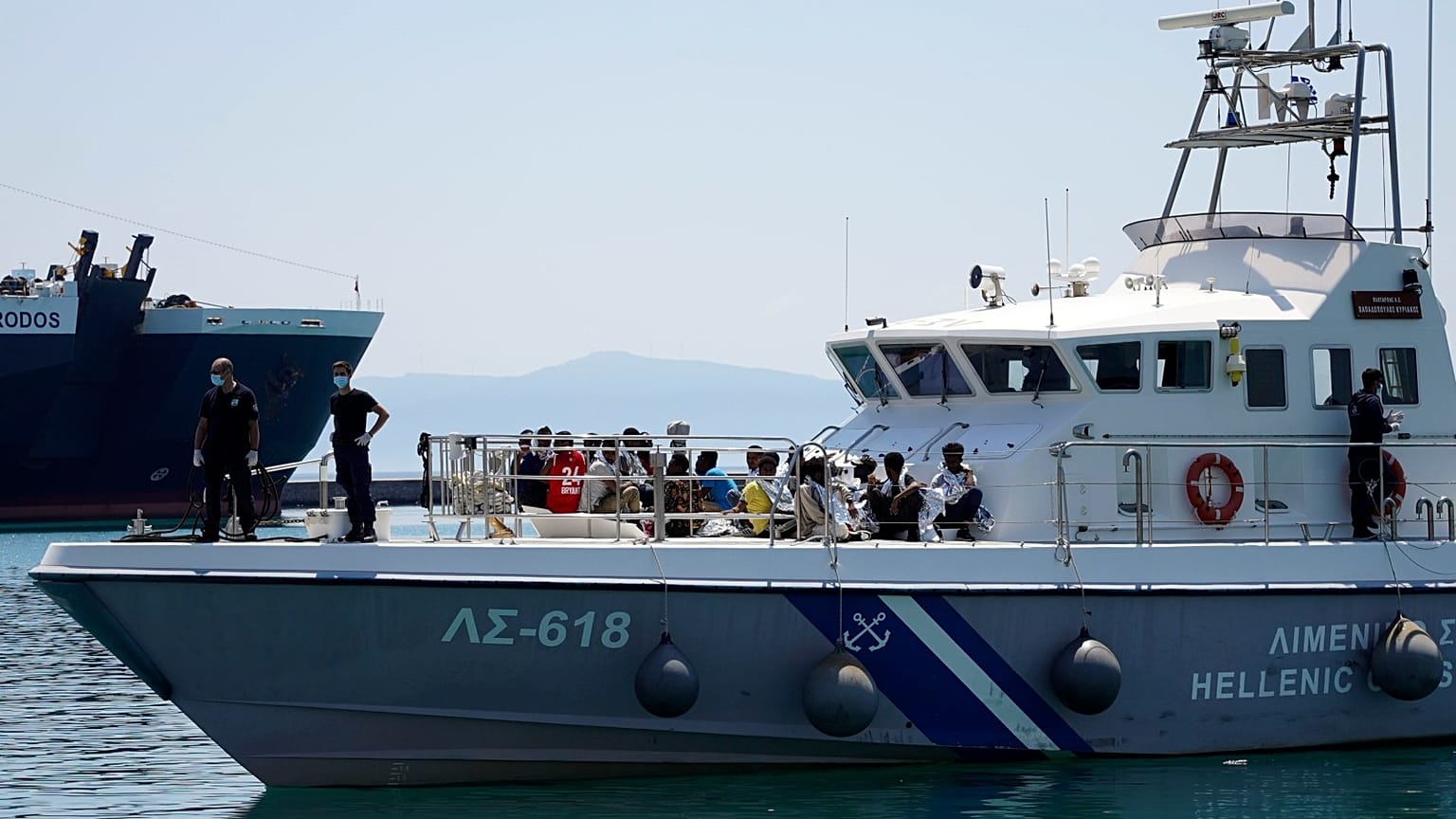 FILE: Migrants sit on the deck of a coast guard vessel upon their arrival at Mytilene port, on the northeastern Aegean Sea island of Lesbos, Greece, Wednesday, June 22, 2022